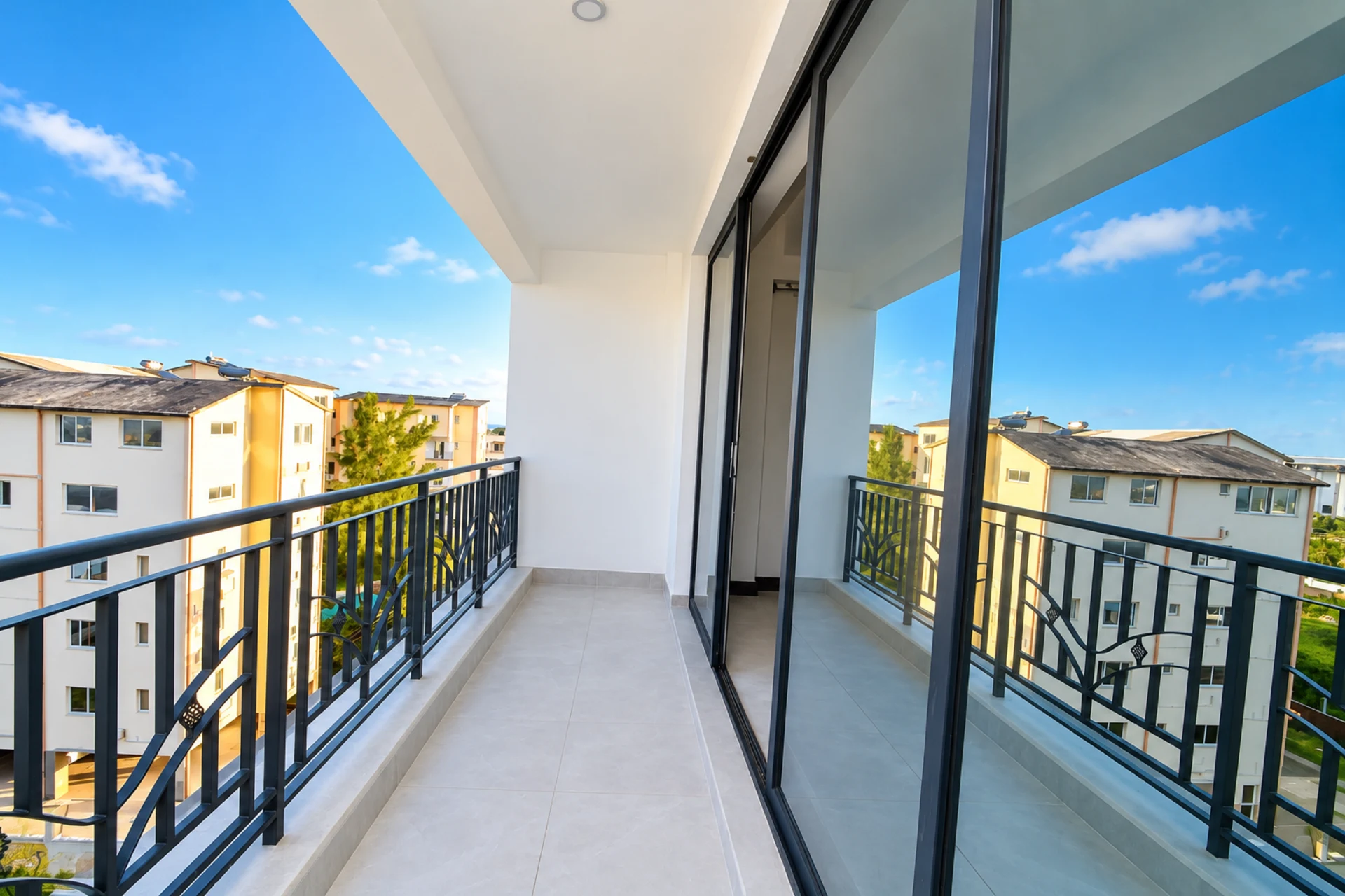 A wide balcony with sliding glass doors and a steel railing