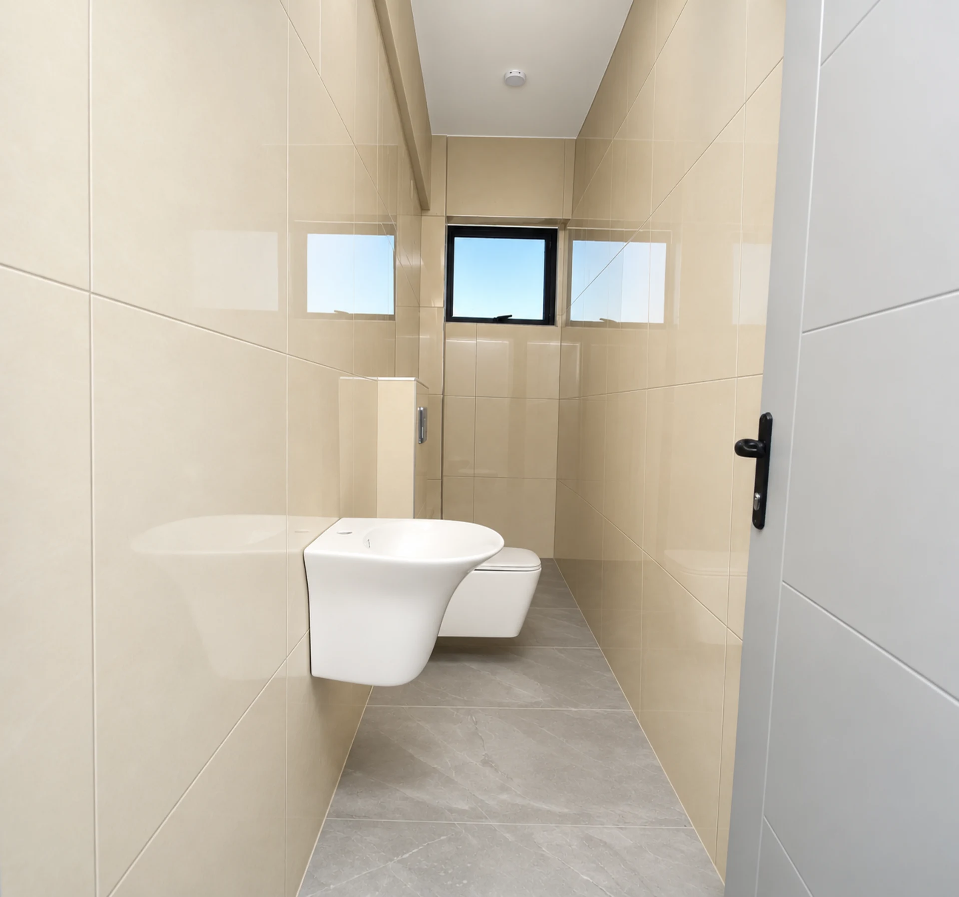 A tiled bathroom with a wall-hung basin and WC