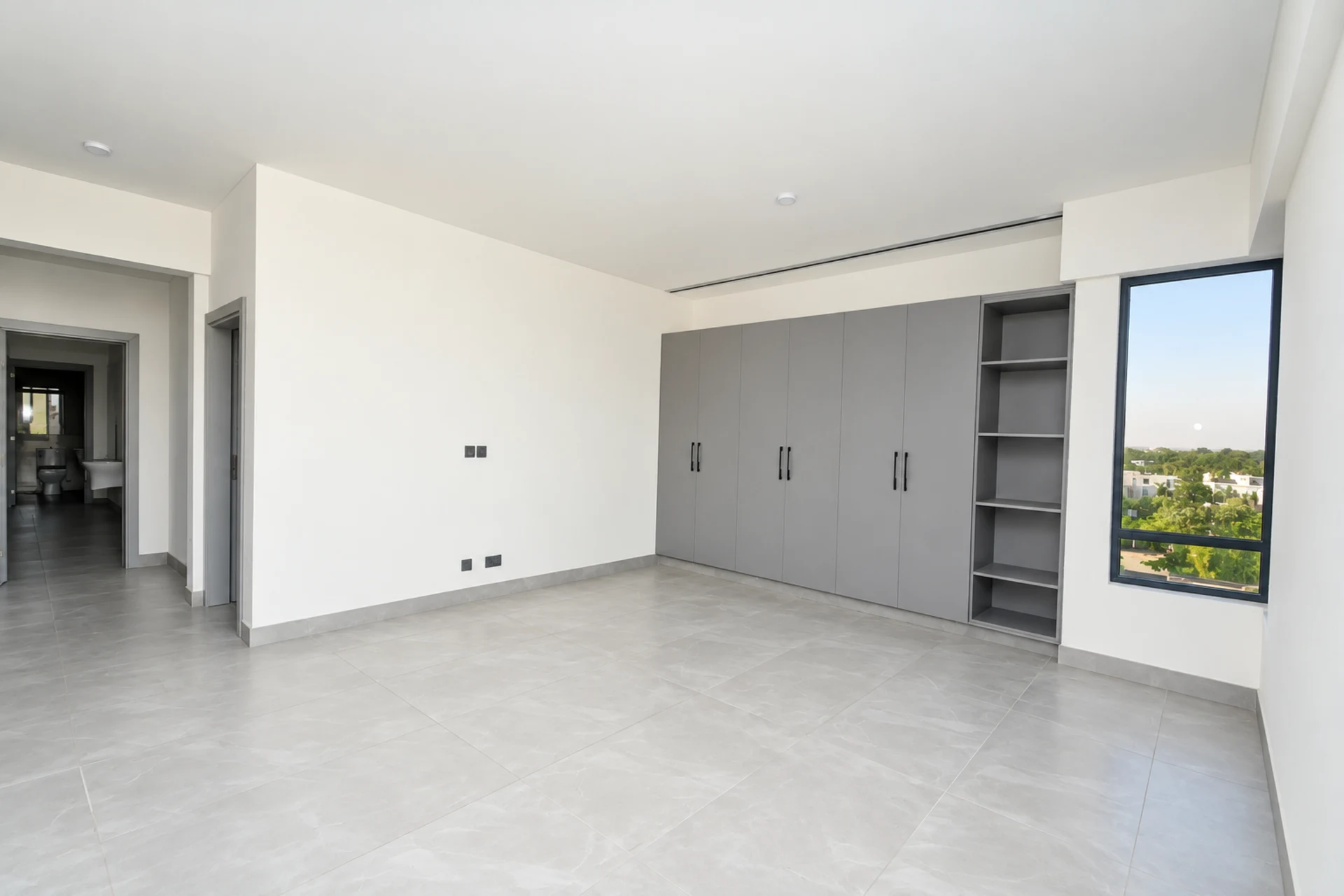 A bedroom with fitted wardrobes and open shelving