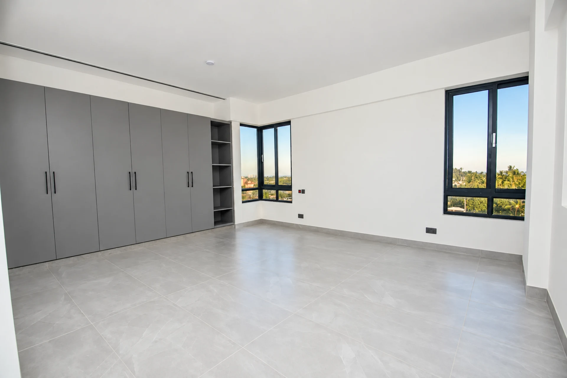 The main bedroom, with built-in wardrobes and a corner window