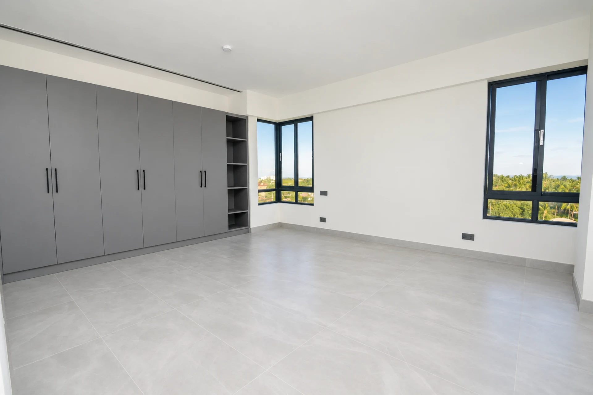 A bedroom with a wall of built-in wardrobes