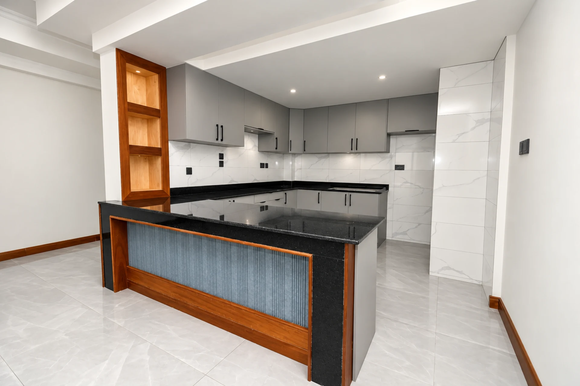 A fitted kitchen with black granite worktops and a timber-framed breakfast bar